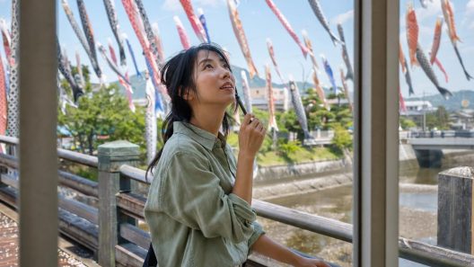 Femme regardant des carpes volantes sur un pont