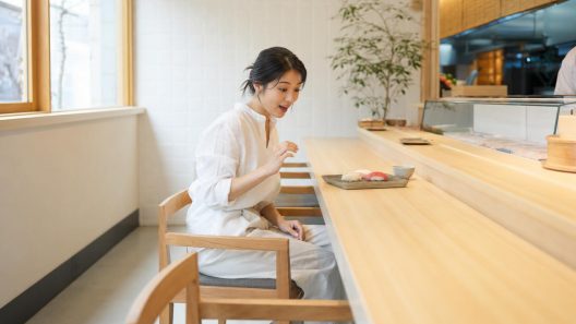 Femme surprise devant des sushis au comptoir