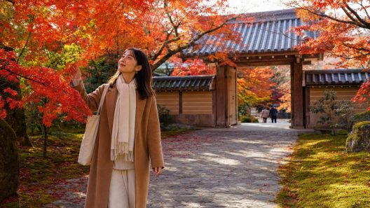 Femme sous érables rouges dans temple japonais