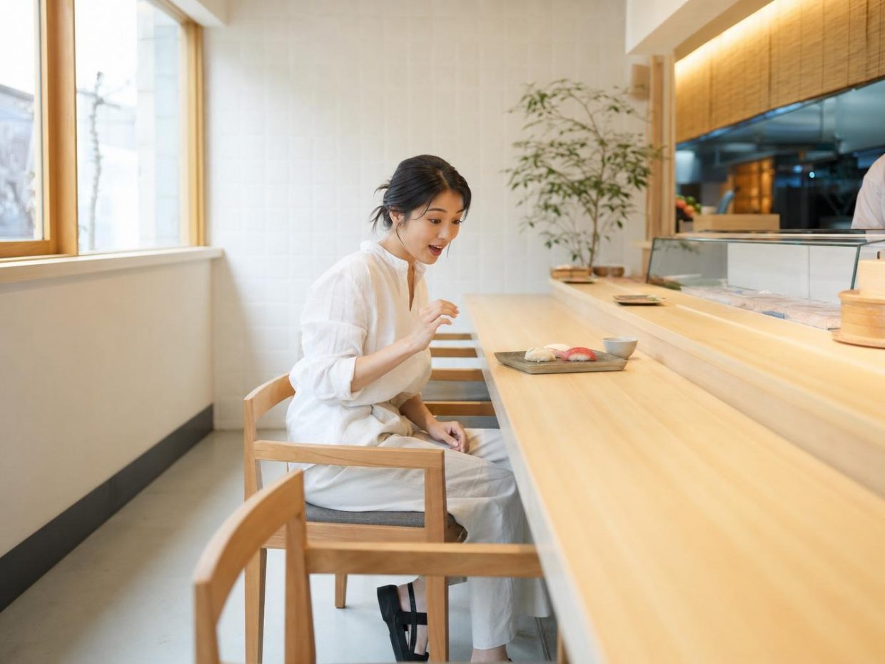 Femme surprise devant des sushis au comptoir