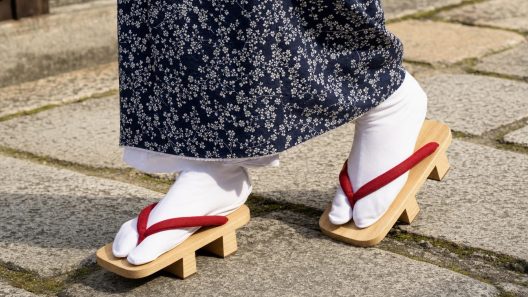 Pieds en tabi blancs portes avec des geta en bois, ourlet de kimono indigo