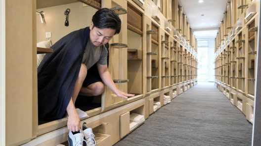 Homme dans un hôtel capsule enfile ses chaussures