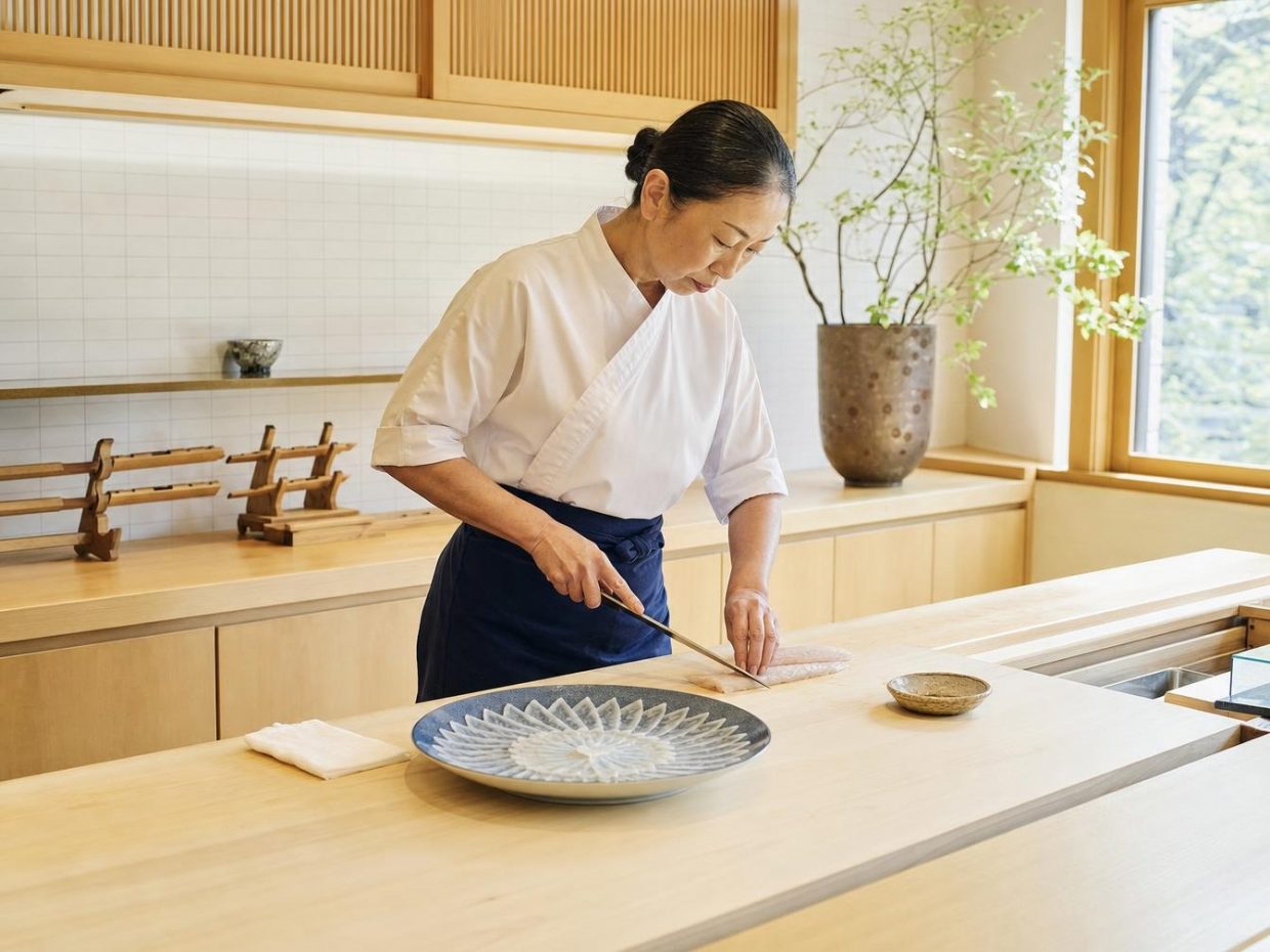 Cheffe japonaise découpant du poisson pour des sashimis