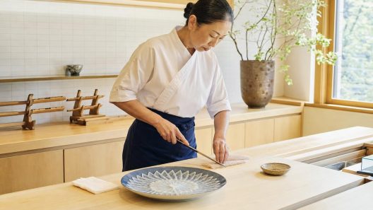 Cheffe japonaise découpant du poisson pour des sashimis