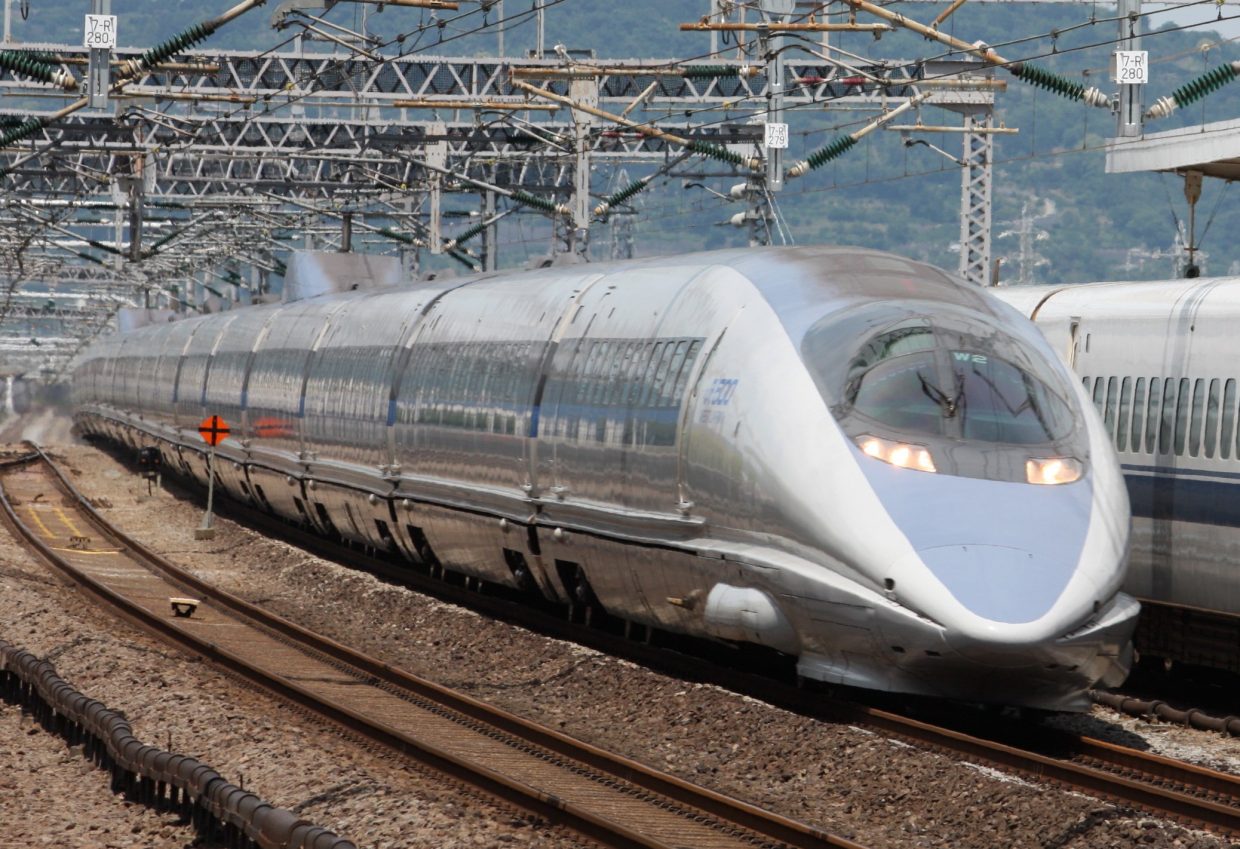 Train à grande vitesse argenté sous caténaires