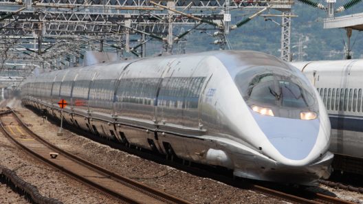 Train à grande vitesse argenté sous caténaires