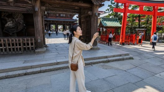 Femme devant un torii rouge dans un sanctuaire japonais
